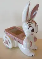 White rabbit figurine pulling a pink wagon.