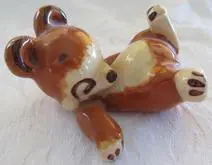 Ceramic bear figurine lying on its side.