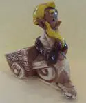 Ceramic figurine of a man in a cart.