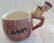 A wooden mug with a boy on the handle.