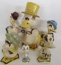 Four ceramic ducks wearing hats and clothes.