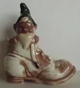 Ceramic gnome figurine sitting in a boot.