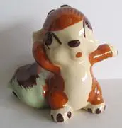 Ceramic figurine of a brown and white squirrel.