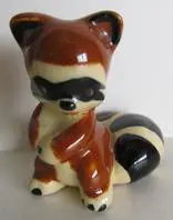 A small ceramic figurine of a raccoon.