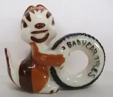 A ceramic squirrel holding a tire.