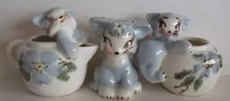 Three ceramic kitten figurines on flower pots.