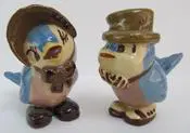 Two bluebird figurines with hats and scarves.