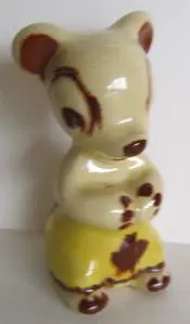 Ceramic figurine of a bear in yellow pants.