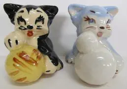 Two ceramic cat figurines with yarn balls.