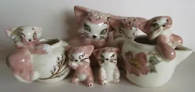 Pink porcelain cat figurines in a group.