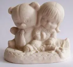 White figurine of a girl and a bear.