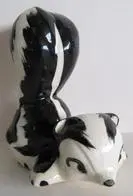 Ceramic figurine of two black and white skunks.