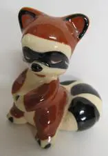 Ceramic figurine of a raccoon sitting.