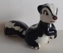 Ceramic figurine of a black and white skunk.