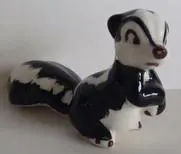 Ceramic figurine of a black and white skunk.