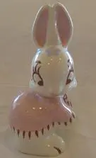 White porcelain bunny figurine with pink dress.