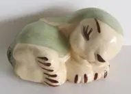 Ceramic figurine of a sleeping dog.