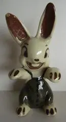 Ceramic rabbit figurine wearing overalls.