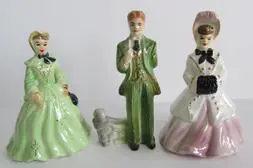 Three porcelain figurines of a couple and dog.