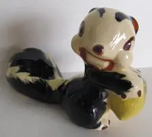 Ceramic figurine of a cartoon skunk.